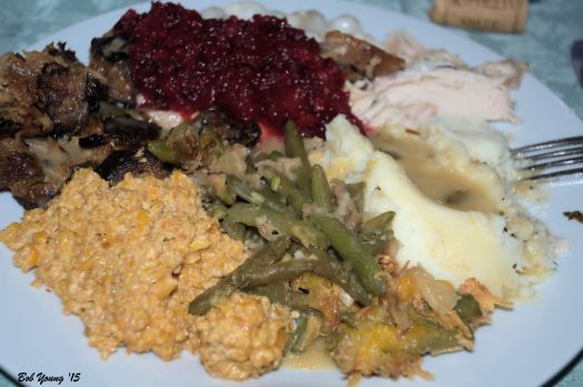 Plated meal: Green Bean Casserole, Dried Corn, Stuffing, Cranberry, turkey and mashed potatoes with gravy.